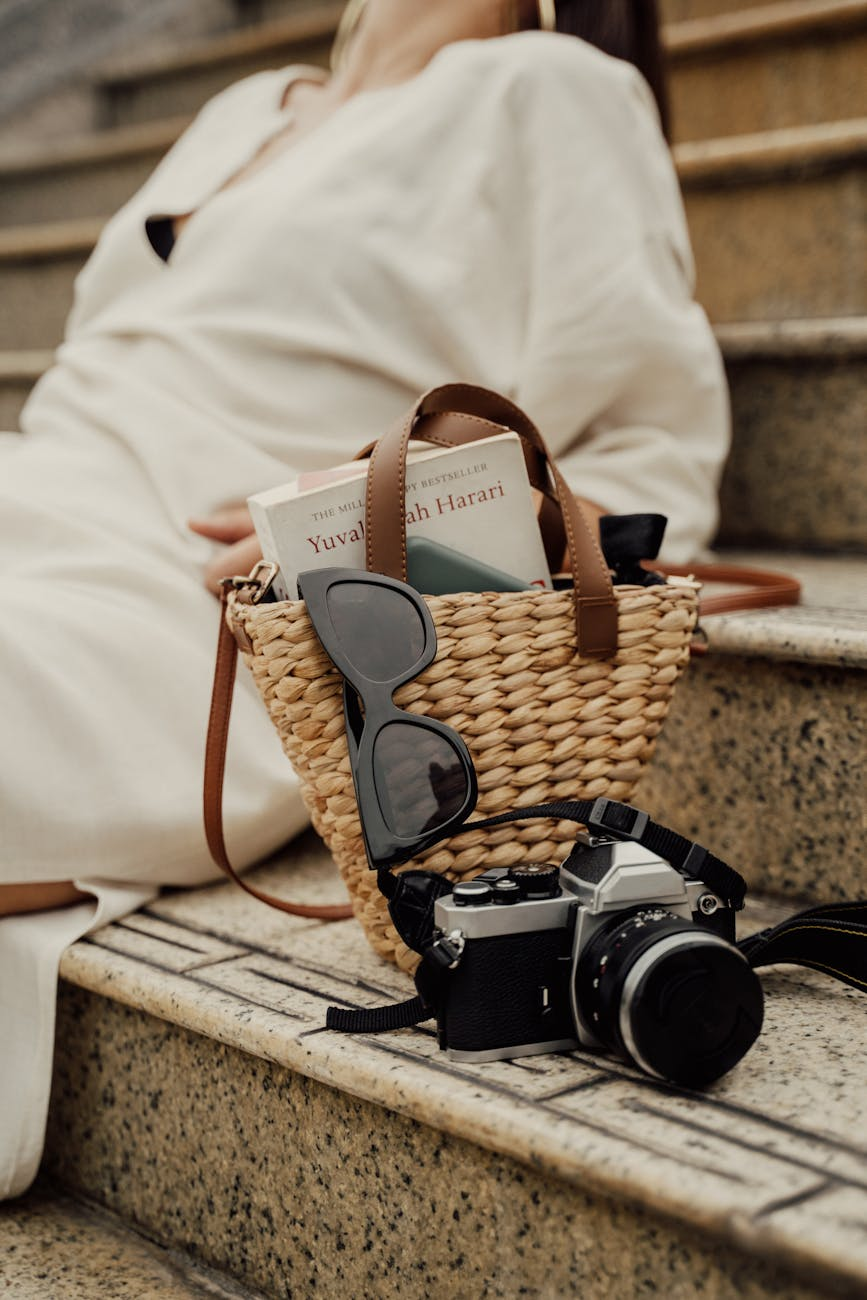 a vintage camera near the woven bag